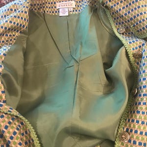 May include: A green and blue patterned jacket with a green lining. The jacket has a label that reads "Adrianna Papell" and "12".