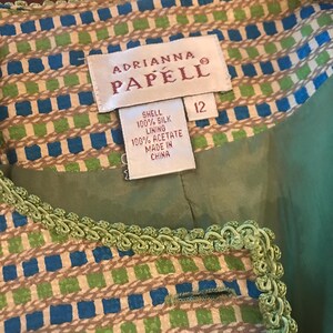 May include: A green and blue patterned jacket with a green trim. The label reads "Adrianna Papell" and "Shell 100% Silk Lining 100% Acetate Made in China" and "12".