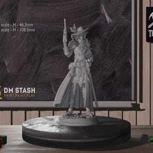 Può includere: Una statuetta in miniatura grigia non dipinta di una persona che indossa un cappello a tesa larga e tiene una pistola. La statuetta è in piedi su una base rotonda. Il testo "DM STASH PRINT.PAINT.PLAY" è visibile sulla base.