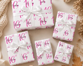 May include: Five rectangular gift boxes wrapped in white paper featuring a repeating pink "16th" pattern and the name "Amelia" in black script. Each box is tied with a smooth white satin ribbon bow centered on the top surface of the package.