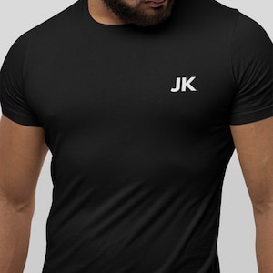 Peut inclure: T-shirt noir avec un logo "JK" blanc sur la poitrine.