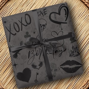 May include: Black and white gift wrap with a gothic theme. The paper features a variety of designs, including hearts, skulls, wings, a castle, and the words "XOXO" and "Happy Birthday".