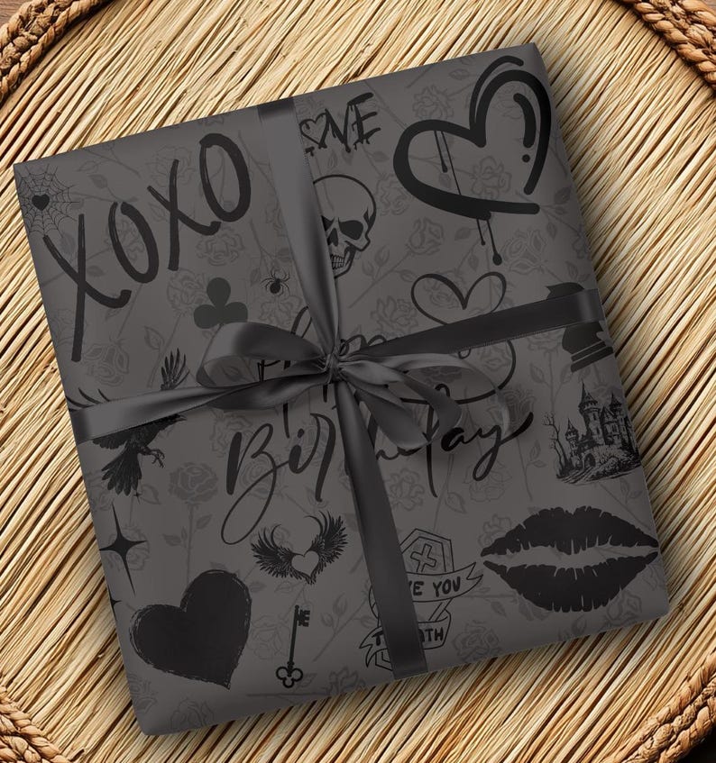 May include: Black and white gift wrap with a gothic theme. The paper features a variety of designs, including hearts, skulls, wings, a castle, and the words "XOXO" and "Happy Birthday".