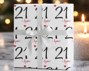 May include: White gift wrap with a repeating pattern of the number 21 and the words "(Again)" in red. The gift wrap is tied with a white ribbon.