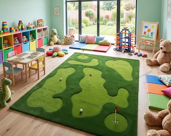 May include: A rectangular area rug featuring a green golf course design with light green fairways, white golf balls, and small red flags marking holes. The rug has the text YARN TRADERS printed on it and is placed in a room with various toys.