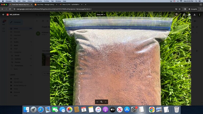 May include: A close-up of a clear plastic bag filled with a brown, granular substance. The bag is lying on a bed of green grass.