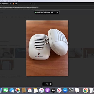 Puede incluir: Dos dispositivos eléctricos repelentes de plagas blancos con un cable de alimentación negro y una luz roja. Los dispositivos están sobre una superficie de madera.