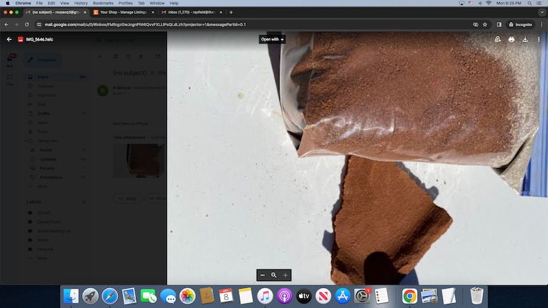 May include: A close-up of a brown powder in a clear plastic bag. The bag is partially open and some of the powder has spilled out onto a white surface.
