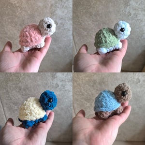 May include: Four handmade crochet turtles in various colors: pink, green, blue, and brown. Each turtle has a contrasting shell and head color, with black button eyes. The turtles are small, soft, and likely intended as toys or decorative items.