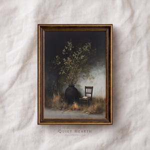 May include: A framed vintage-style print featuring a dark vase filled with branches and flowers. A small wooden chair with a book sits nearby. The artwork has a dark, moody aesthetic with a gold-colored frame. The text "QUIET HEARTH PRINTS" is at the bottom.