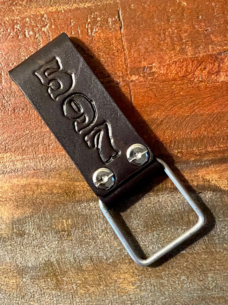 May include: A brown leather key chain with a metal ring and the number "5927" embossed on it.