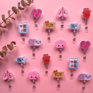 Può includere: Una collezione di 14 rotoli di badge ricamati colorati con vari disegni a tema medico, tra cui un cuore, i polmoni, il cervello, una pillola, un bendaggio, una siringa e una cartella. Ogni disegno ha un simpatico viso da cartone animato.