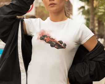 May include: A white t-shirt featuring a watercolour illustration of a red racing car on the front. The car is surrounded by a cloud of smoke.