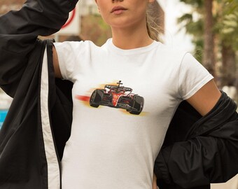 May include: A white t-shirt featuring a graphic of a red and black racing car speeding on a blurred background.
