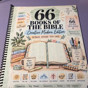 May include: A spiral-bound Bible study workbook titled 66 Books of the Bible Creative Modern Edition. The cover features illustrations of an open Bible, a mug, a jar of pens, and stacked books, with text including Read, Study, Reflect, Grow, Be Encouraged, and Abide in Joy Boutique.