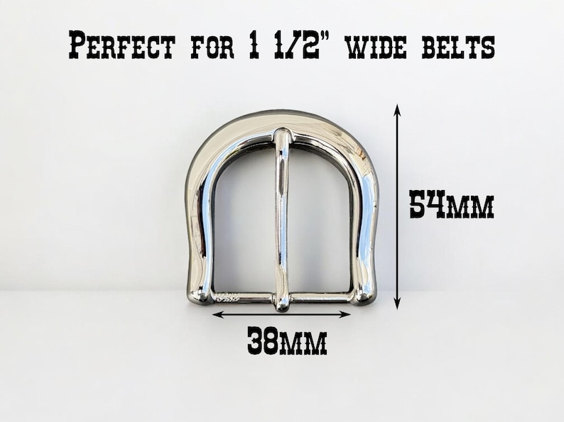 May include: Silver metal belt buckle measuring 1 1/2 inches wide. The buckle is 54 mm tall and 38 mm wide.