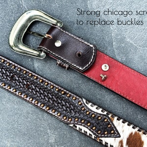 May include: A brown leather belt with a silver buckle and a braided design. The belt has a red lining and two silver screws. The text "Strong chicago screws to replace buckles" is visible in the image.