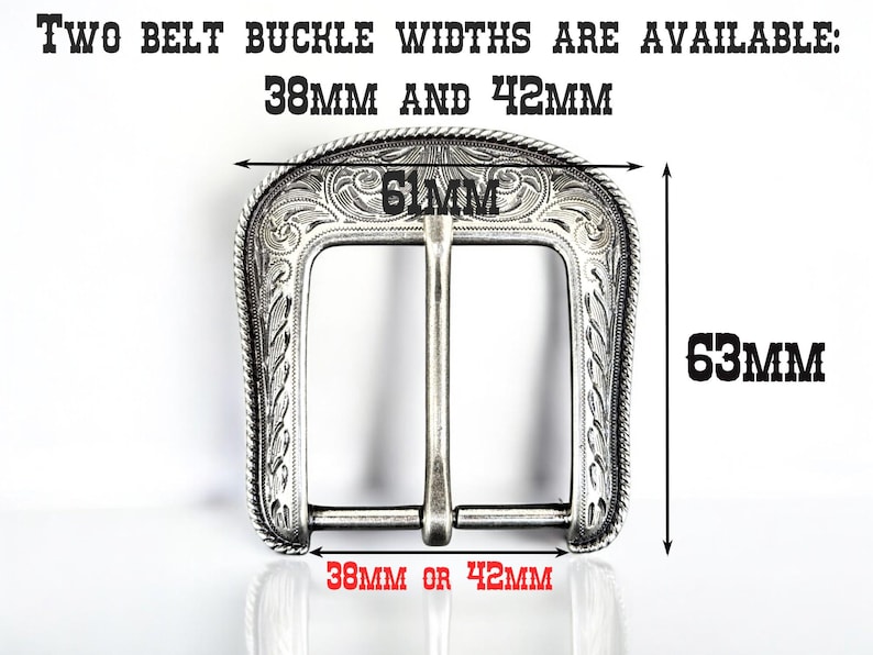 Puede incluir: Hebilla de cintur&oacute;n plateada con un dise&ntilde;o ornamentado. La hebilla tiene forma rectangular con esquinas redondeadas y una barra central. El texto indica dos anchos disponibles: 38 mm o 42 mm. La hebilla mide 61 mm de ancho y 63 mm de alto.