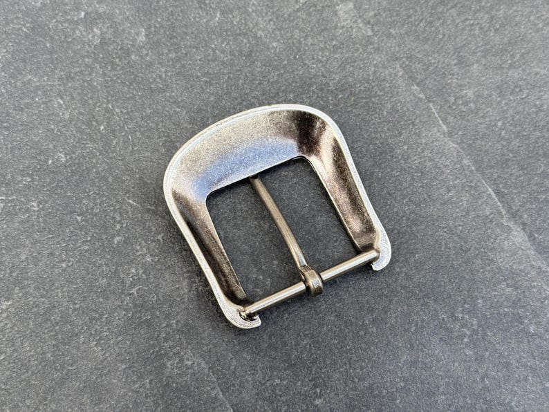Puede incluir: Hebilla de cintur&oacute;n de metal plateado, de forma rectangular con una barra central. La hebilla tiene un acabado ligeramente desgastado, lo que le da un aspecto vintage. Dise&ntilde;ada para usar con un cintur&oacute;n.