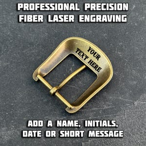 Puede incluir: Una hebilla de cintur&oacute;n de metal de color bronce con el texto "YOUR TEXT HERE" grabado. La hebilla es rectangular con bordes redondeados y una barra central. La imagen tambi&eacute;n incluye el texto "PROFESSIONAL PRECISION FIBER LASER ENGRAVING" y "ADD A NAME, INITIALS, DATE OR SHORT MESSAGE."