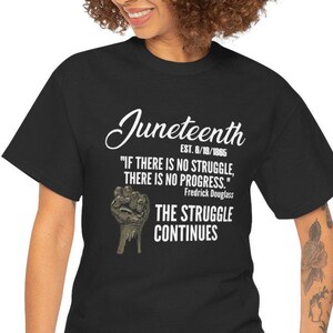 May include: A black short-sleeved t-shirt featuring white text that reads Juneteenth EST. 6/19/1865, If there is no struggle, there is no progress. Frederick Douglass, and The struggle continues, along with a graphic of a raised fist.