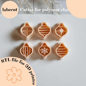 May include: Six beige polymer clay cutters in an ornament shape. Each cutter has a different interior design, including a cross, stripes, a star, a snowflake, and vertical lines. The image includes the text "labecut Cutter for polymer clay" and "STL file for 3D printer."