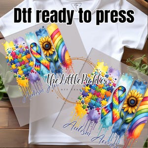 May include: Two digital transfer designs featuring a rainbow, tie-dye ribbon, sunflower, and puzzle pieces. The text "Autism Awareness" is included in both designs.