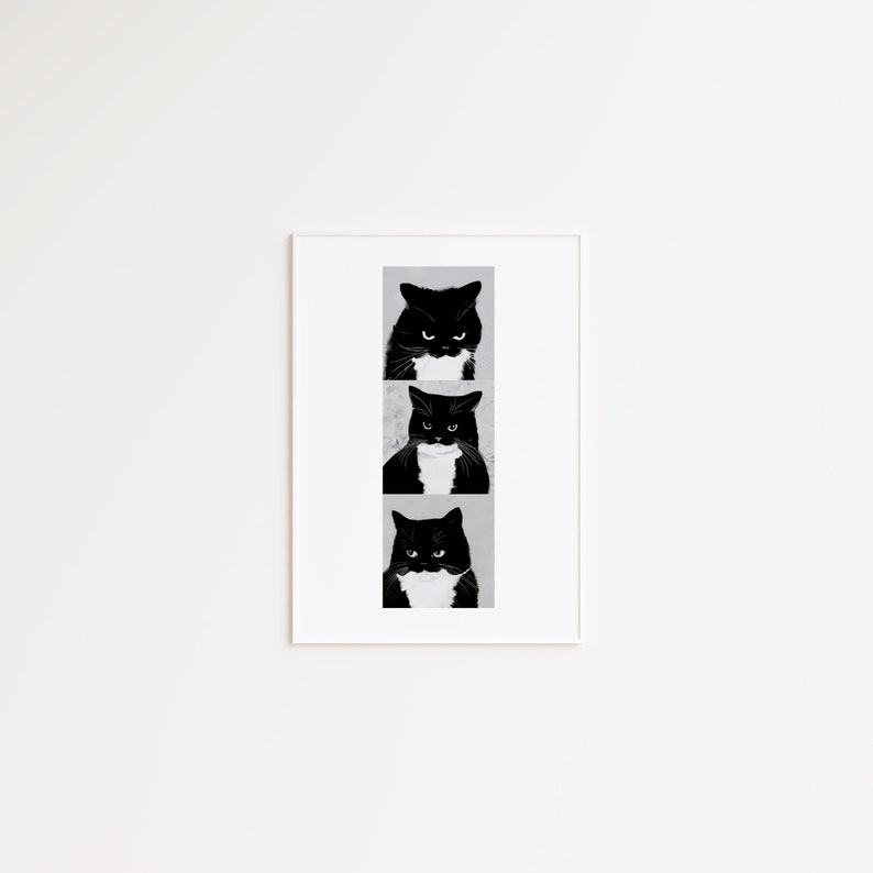 May include: A framed art print featuring three black and white cat portraits. Each cat has a stern expression and a white patch on its chest. The artwork is displayed in a white frame against a white wall.