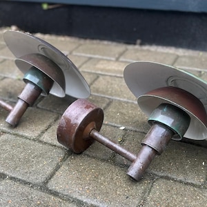Puede incluir: Dos apliques de pared vintage con acabado marr&oacute;n y pantalla blanca y verde. Los apliques tienen una base circular y un brazo curvo. Las pantallas son circulares e inclinadas hacia abajo.