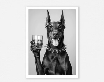 May include: Black and white photograph of a Doberman Pinscher holding a glass of whiskey with ice. The dog wears a studded collar and has its tongue out. The image is a portrait against a plain background.