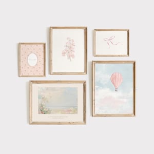 May include: A gallery wall with five framed prints. The prints feature a pink floral design, a pink hot air balloon, a pink and white patterned design with the word "love", and two abstract watercolor paintings.