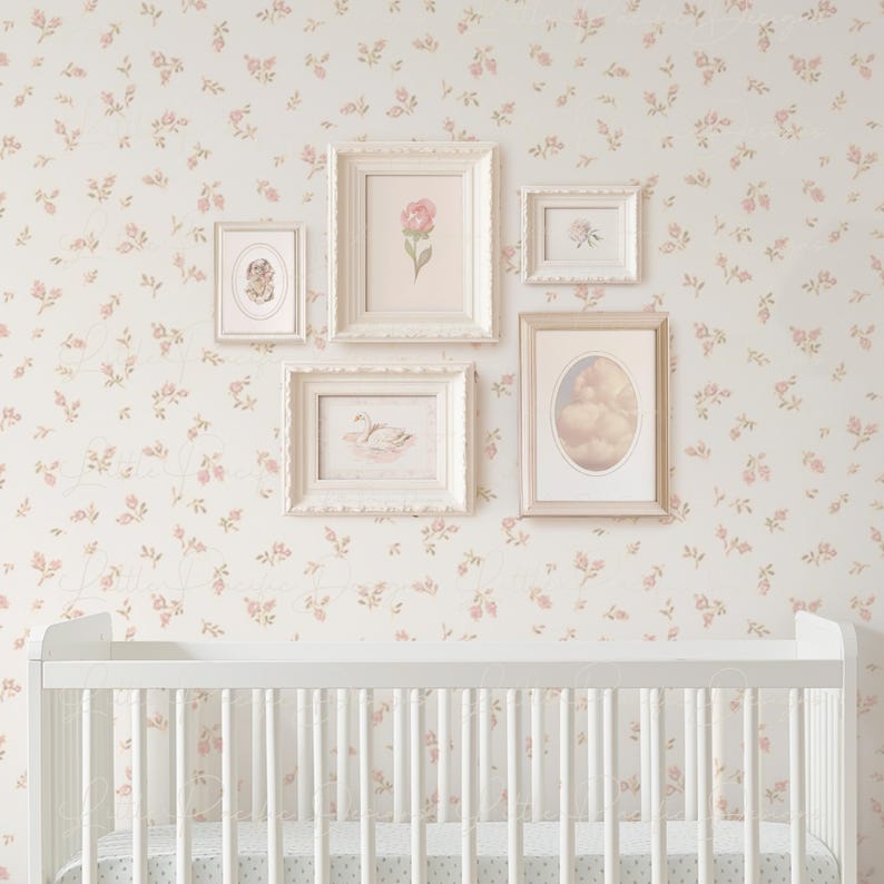 K&ouml;nnte beinhalten: Ein wei&szlig;es Babybett vor einem Hintergrund aus wei&szlig;er und rosa Blumentapete. Die Tapete hat ein zartes Muster aus kleinen rosa Bl&uuml;ten und gr&uuml;nen Bl&auml;ttern. An der Wand h&auml;ngen f&uuml;nf wei&szlig;e Bilderrahmen, jeder mit einem anderen Bild.