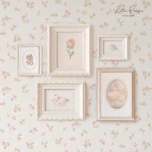 K&ouml;nnte beinhalten: F&uuml;nf wei&szlig;e und goldene verzierte Bilderrahmen mit verschiedenen Bildern darin. Die Rahmen h&auml;ngen an einer Wand mit einem Blumenmuster. Die Bilder zeigen eine einzelne rosa Blume, einen Schwan, eine Wolke und ein kleines Tier.