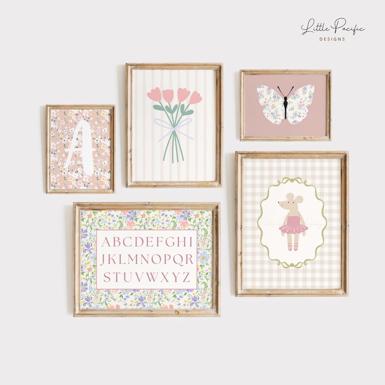 May include: A collection of framed art prints with a floral and alphabet theme. The prints feature a pink and white color scheme, with images of flowers, a butterfly, a mouse ballerina, and the alphabet. The frames are a light brown color.