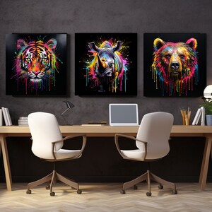 May include: Three colorful animal head paintings on black canvases. The paintings are of a tiger, a rhinoceros, and a bear. The paintings are hung on a dark gray wall in a home office setting.