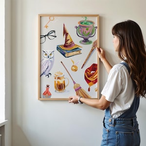 May include: A framed print with a white background and colorful illustrations of various Harry Potter themed objects, including a witch's hat, a golden snitch, a broom, a potion bottle, a book, a key, a pair of glasses, a snowy owl, a butterbeer, and a cauldron.