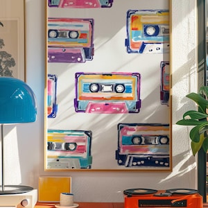 May include: A framed print with a white background and a repeating pattern of colorful cassette tapes. The tapes are painted in a variety of colors, including pink, blue, yellow, and green.