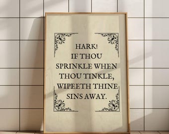 May include: A framed print with a light beige background and black text that reads: "Hark! If thou sprinkle when thou tinkle, wipeth thine sins away." Decorative corner flourishes frame the text. The frame is a light brown color.