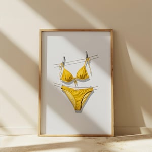 Könnte beinhalten: Ein gelber Bikini, der an einer Wäscheleine hängt, gerahmt in einem Holzrahmen. Der Bikini ist ein zweiteiliger Satz mit einem Dreiecks-Oberteil und einem hochgeschnittenen Unterteil.