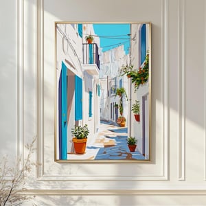 Può includere: Una stampa artistica incorniciata raffigurante un vicolo soleggiato in un villaggio mediterraneo. L'opera presenta edifici bianchi con persiane e porte blu, piante in vaso e un cielo azzurro. La stampa è in una cornice dorata.