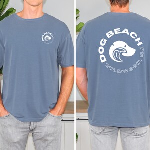 May include: A blue t-shirt with a white graphic on the back that says "Dog Beach Wildwood, NJ".