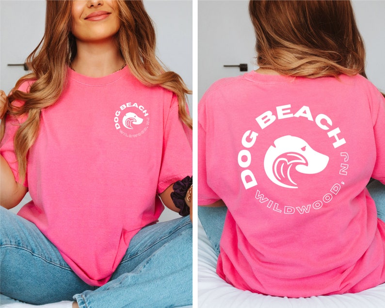 May include: Pink t-shirt with a white circle graphic on the front and back. The graphic says "Dog Beach Wildwood, NJ" and features a dog's head with a wave.