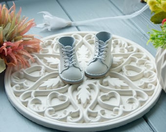May include: A pair of white leather ankle boots with blue laces and a white heart-shaped design on a white background.