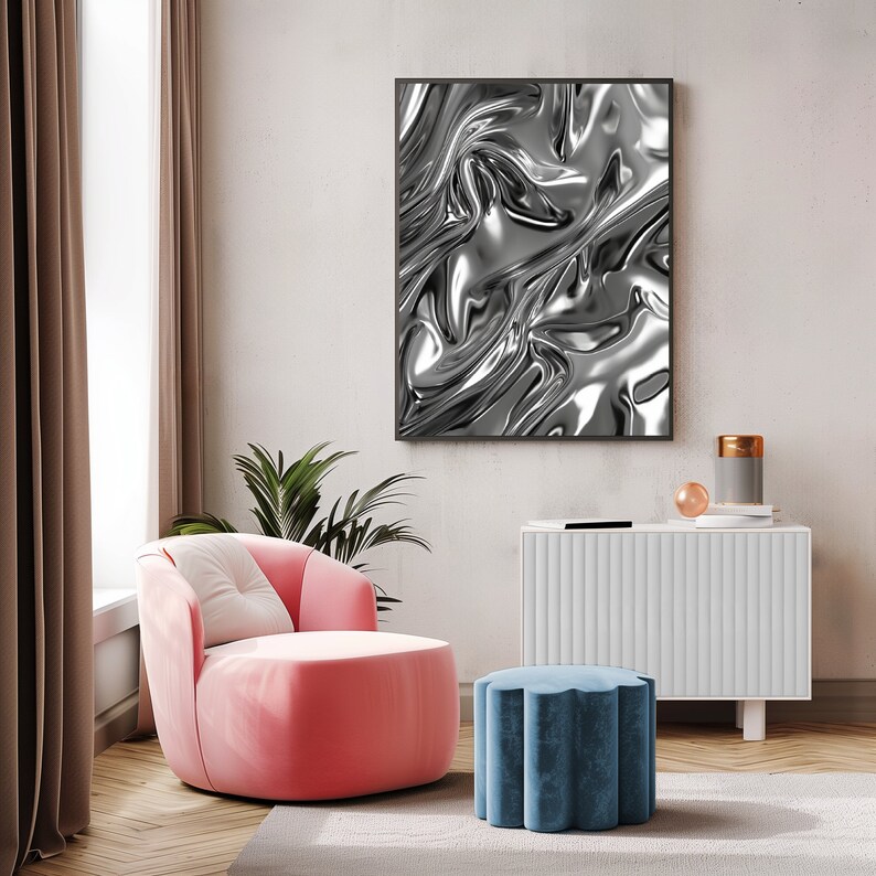 May include: A pink armchair with a white cushion sits in a living room with a white cabinet and a blue ottoman. A framed black and white abstract print hangs on the wall behind the chair.