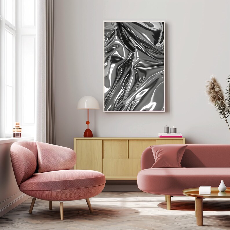 May include: A living room interior design featuring a pink sofa and armchair, a wooden cabinet, a lamp, and a framed black and white abstract print of a metallic fabric.