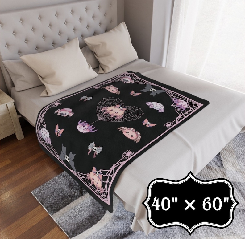 May include: A black and pink fleece throw blanket with a spiderweb design and cute cartoon spiders. The blanket is 40 inches by 60 inches.