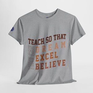 May include: Gray t-shirt with the text "Teach so that they can dream excel believe" printed in brown, orange, and pink.