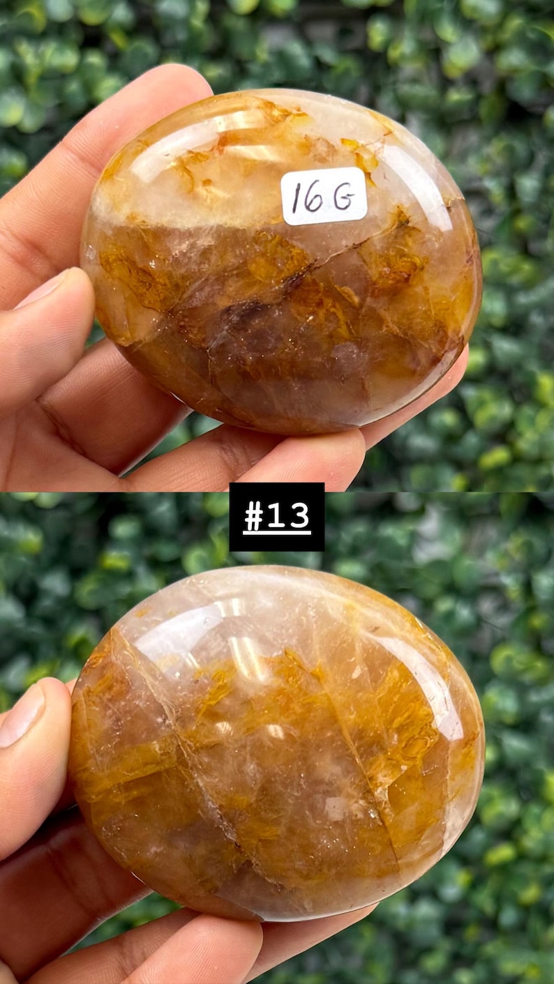 May include: A polished, oval-shaped gemstone with a mix of golden and brown hues. The stone has a smooth, glossy surface and is labeled with "16 G" in a white rectangle. The image also includes the text "#13".