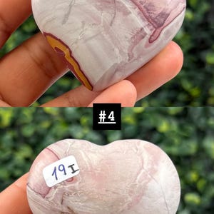 May include: A heart-shaped stone with a mix of pink, white, and yellow hues. The stone has a marbled appearance with a smooth, polished surface. The image includes the text "#4" and a sticker with the text "19I".