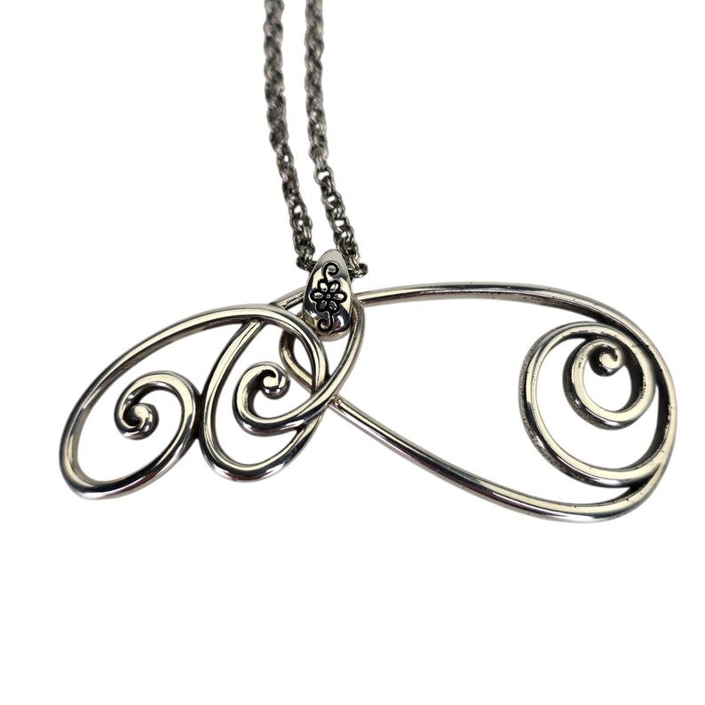 Może przedstawiać: Srebrny naszyjnik z wisiorkiem o abstrakcyjnym wzorze. Wisiorek ma wirujący, ażurowy wz&oacute;r z kwiatowym akcentem na g&oacute;rze, gdzie łączy się z łańcuszkiem. Łańcuszek jest delikatny, w stylu ogniw.